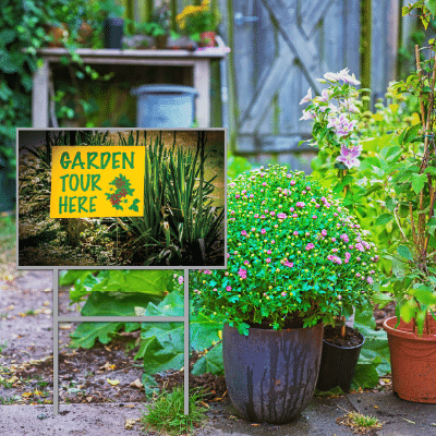 June 26, Annual Garden Walk: "Garden Tour Here" yard sign in a flower-filled garden with potted chrysanthemums.